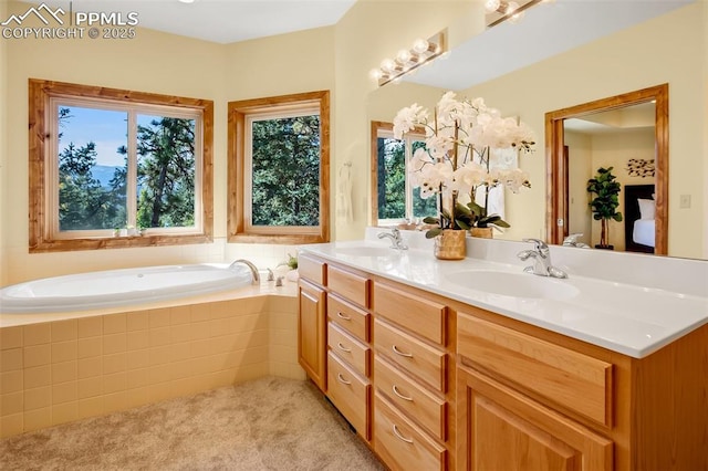 bathroom featuring a relaxing tiled tub and vanity