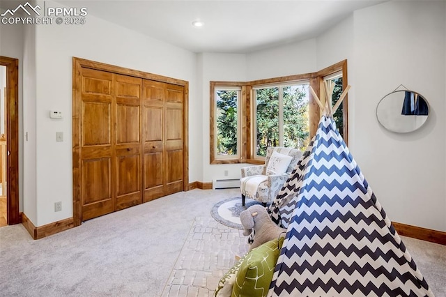 playroom featuring carpet floors and a baseboard heating unit