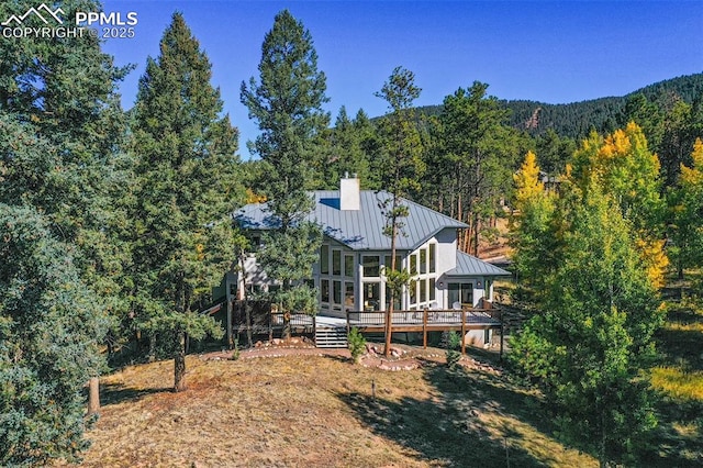 rear view of house featuring a wooden deck and a sunroom