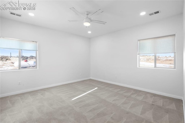 empty room featuring ceiling fan and light carpet