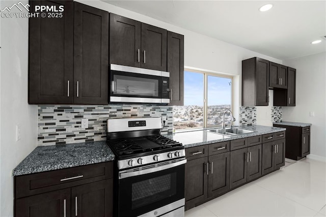 kitchen featuring stainless steel appliances, sink, tasteful backsplash, stone countertops, and dark brown cabinets