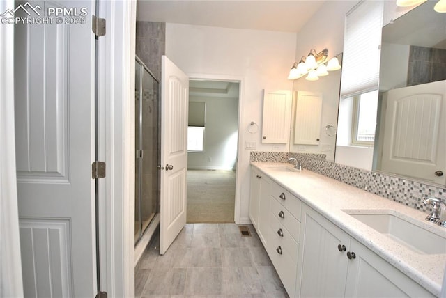 bathroom with an enclosed shower, vanity, and tile patterned flooring