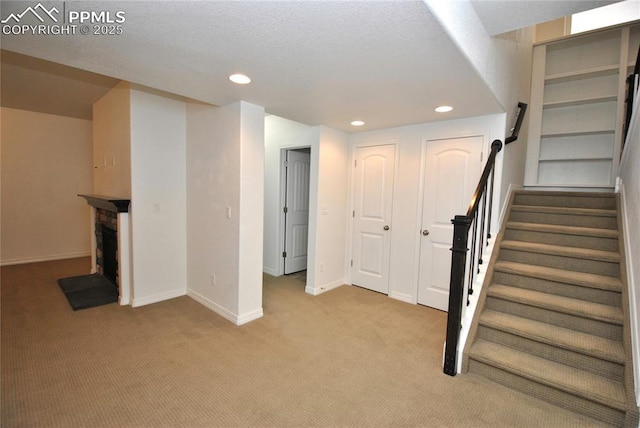 basement with a fireplace and light colored carpet