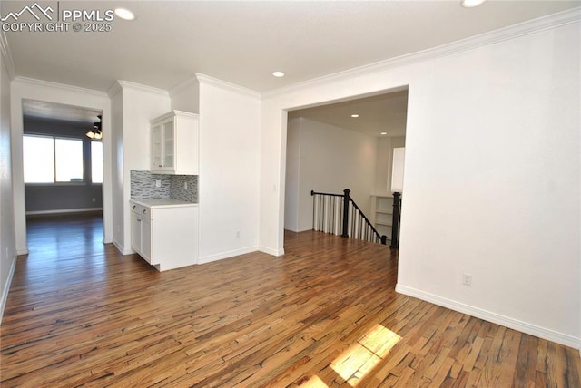 unfurnished living room featuring crown molding and hardwood / wood-style floors