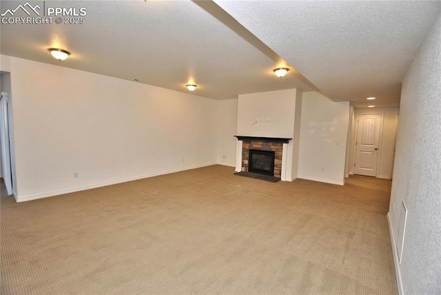 unfurnished living room featuring a textured ceiling, light carpet, and a stone fireplace