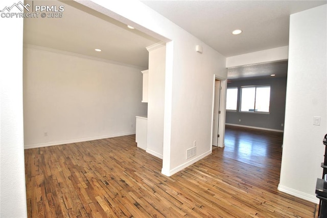 unfurnished room with wood-type flooring and crown molding