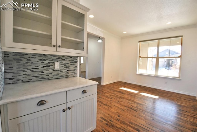 kitchen with backsplash, crown molding, and dark wood-type flooring