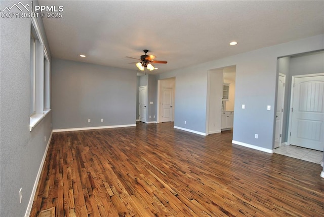 empty room with ceiling fan and dark hardwood / wood-style floors