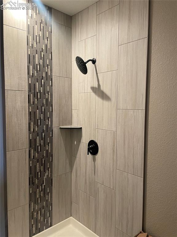 full bathroom featuring tiled shower