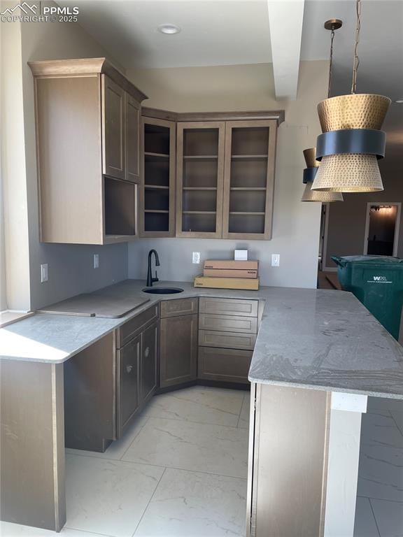 kitchen featuring a sink, a peninsula, glass insert cabinets, marble finish floor, and recessed lighting