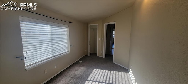 interior space featuring carpet, lofted ceiling, and baseboards