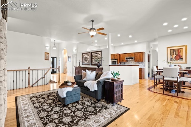 living room with ceiling fan and light wood-type flooring