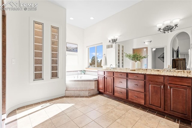 bathroom featuring tiled bath, vanity, a notable chandelier, and tile patterned flooring