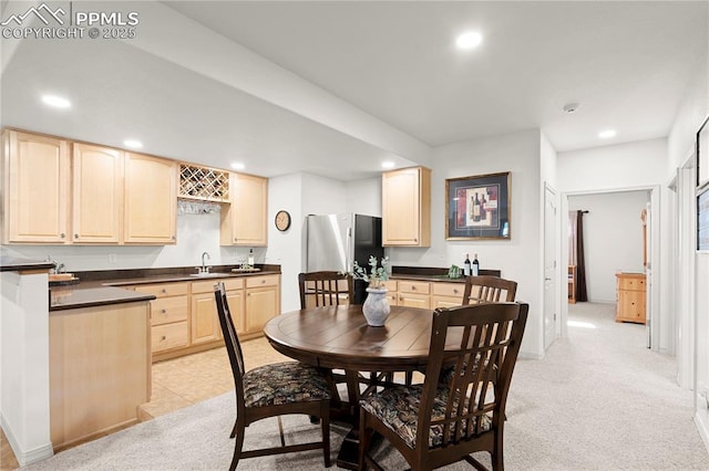 dining room featuring indoor wet bar and light carpet