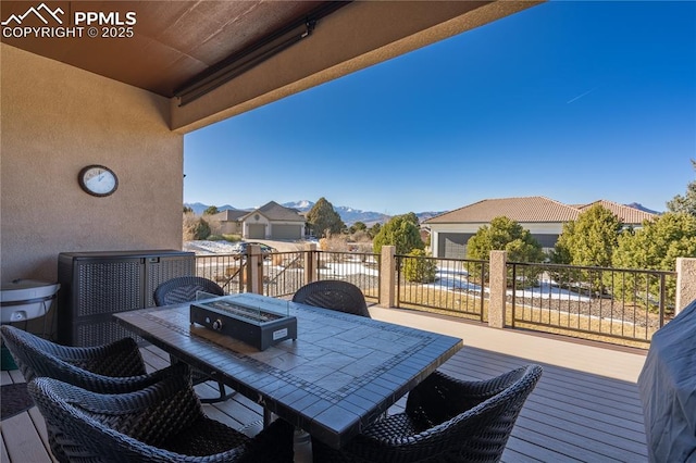 wooden deck featuring a mountain view and a fire pit