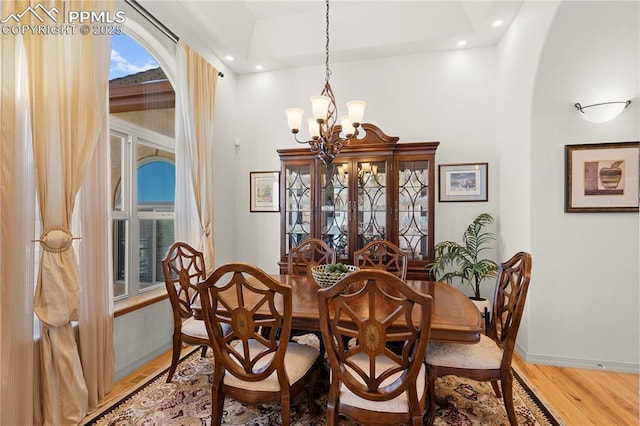 dining space with wood-type flooring and a chandelier