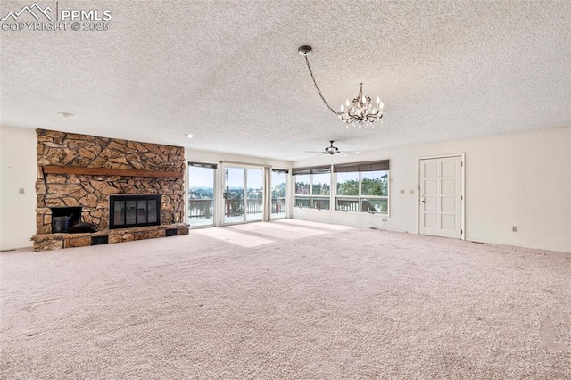 unfurnished living room with ceiling fan with notable chandelier, a stone fireplace, carpet, and a textured ceiling