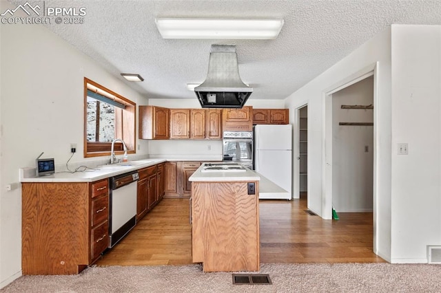 kitchen with a center island, appliances with stainless steel finishes, a textured ceiling, island exhaust hood, and sink