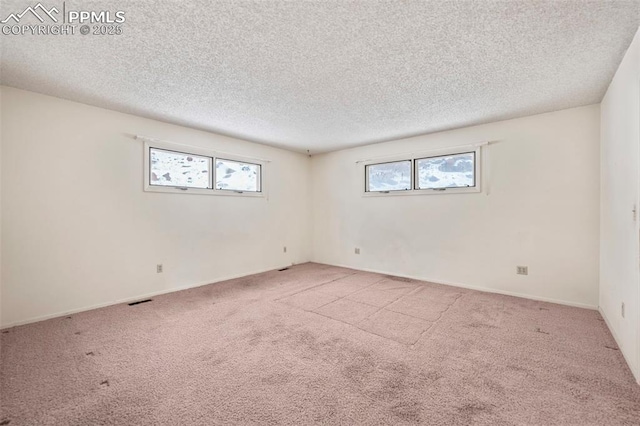 carpeted spare room with a textured ceiling