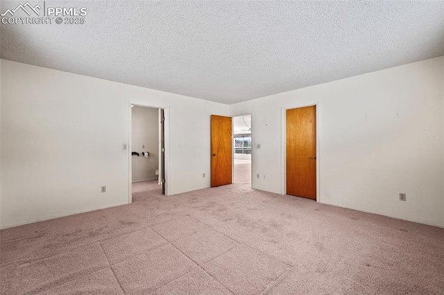 carpeted empty room with a textured ceiling