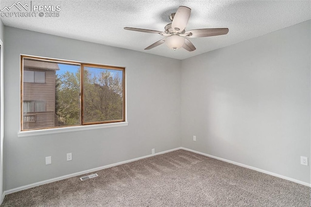 empty room featuring ceiling fan, carpet, and a textured ceiling