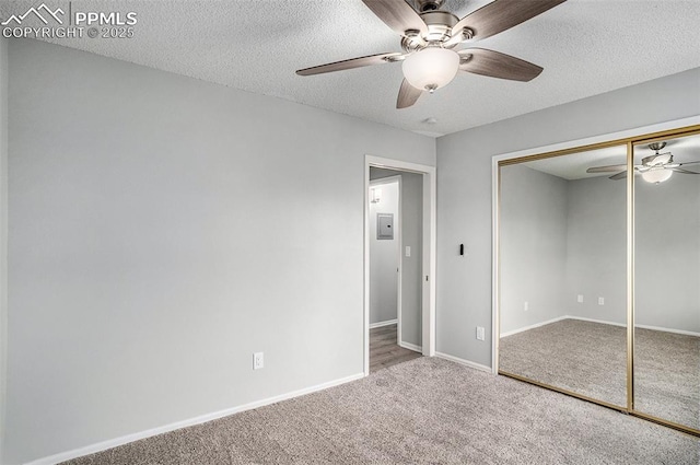 unfurnished bedroom featuring a closet, ceiling fan, carpet flooring, and a textured ceiling