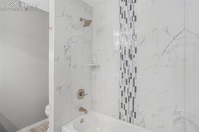 bathroom with toilet and tiled shower / bath combo