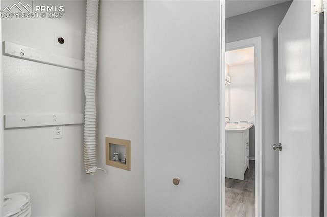 laundry room featuring hookup for a washing machine, hardwood / wood-style floors, sink, and hookup for an electric dryer