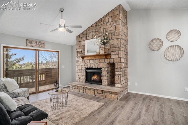 living room with hardwood / wood-style flooring, lofted ceiling, ceiling fan, and a fireplace