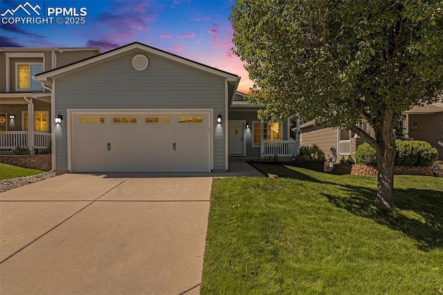 view of front of property with a lawn, covered porch, and a garage