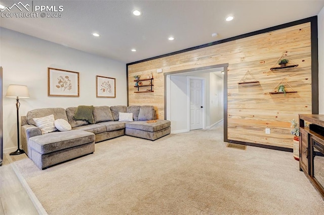 living room with light colored carpet and wooden walls