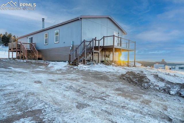 snow covered property featuring a wooden deck