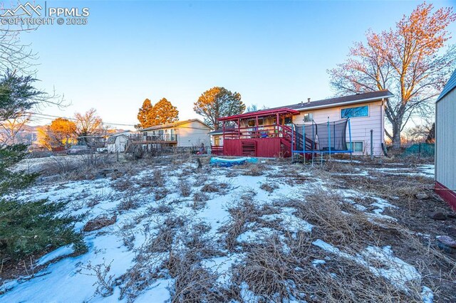 2841 Pinnacle Dr, Colorado Springs, CO 80910 - yard layered in snow with a trampoline and a deck