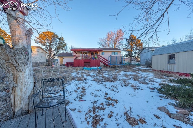 2841 Pinnacle Dr, Colorado Springs, CO 80910 - yard layered in snow with a wooden deck