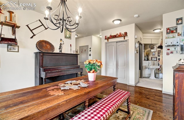 dining space with dark hardwood / wood-style flooring and a chandelier