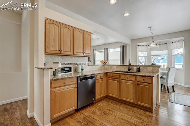 kitchen featuring sink, hanging light fixtures, light stone countertops, and stainless steel dishwasher