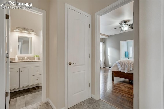 bathroom with wood-type flooring, ceiling fan, and vanity