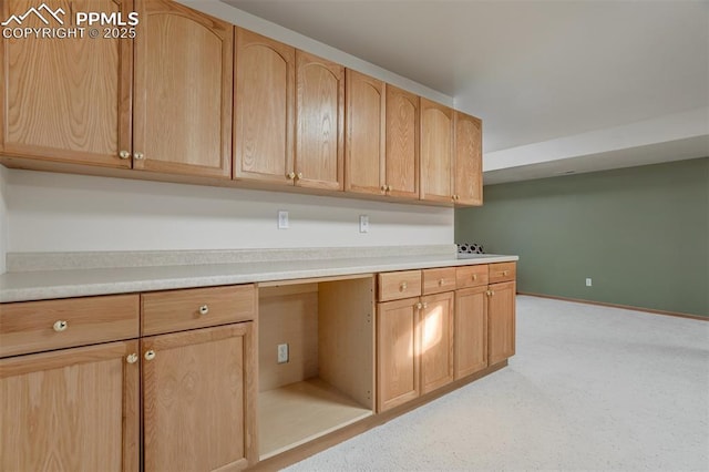 kitchen featuring light brown cabinets and built in desk