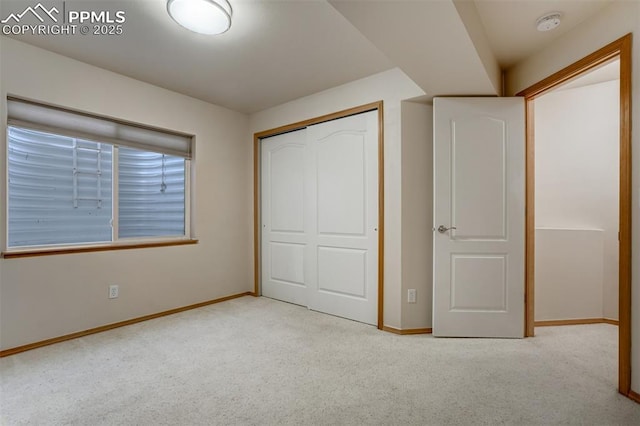 unfurnished bedroom with light colored carpet and a closet