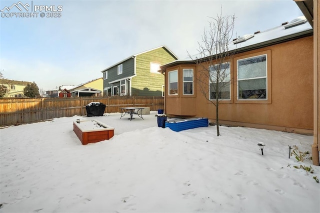 view of snow covered back of property