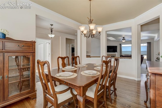 dining room with hardwood / wood-style flooring, an inviting chandelier, and ornamental molding