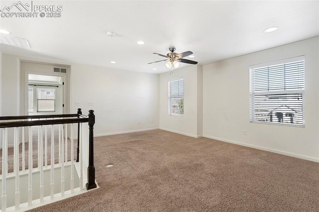 carpeted empty room featuring ceiling fan and plenty of natural light