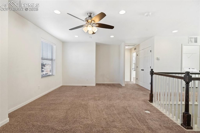 spare room with ceiling fan and light colored carpet