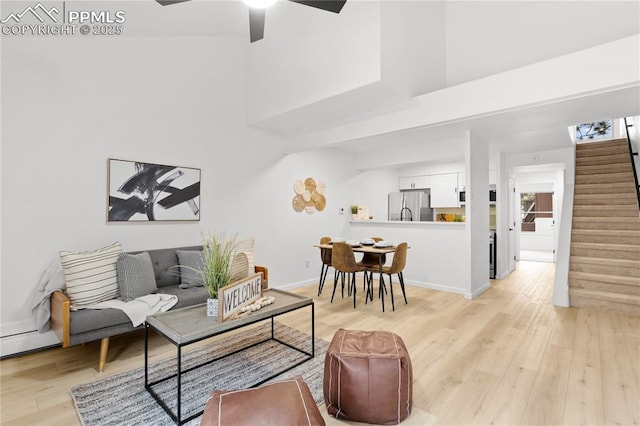 living room featuring ceiling fan and light hardwood / wood-style flooring