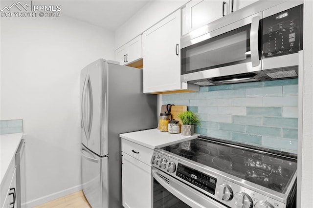 kitchen featuring white cabinets, stainless steel appliances, and backsplash