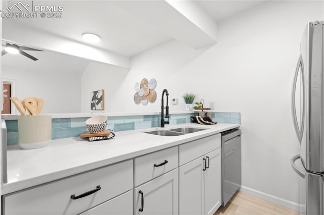 kitchen with appliances with stainless steel finishes, ceiling fan, white cabinets, and sink