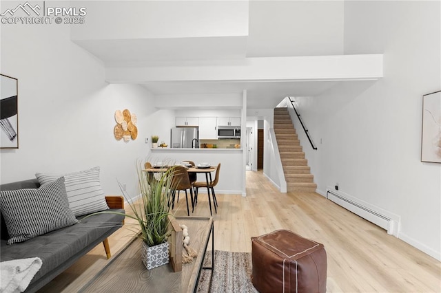 living room featuring a baseboard radiator and light hardwood / wood-style flooring