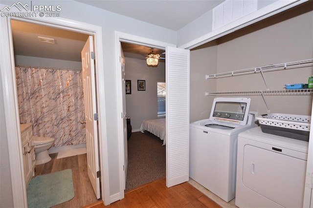 clothes washing area with separate washer and dryer and light hardwood / wood-style floors