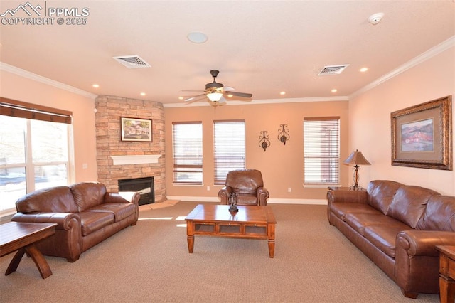 carpeted living room featuring ceiling fan, plenty of natural light, crown molding, and a fireplace