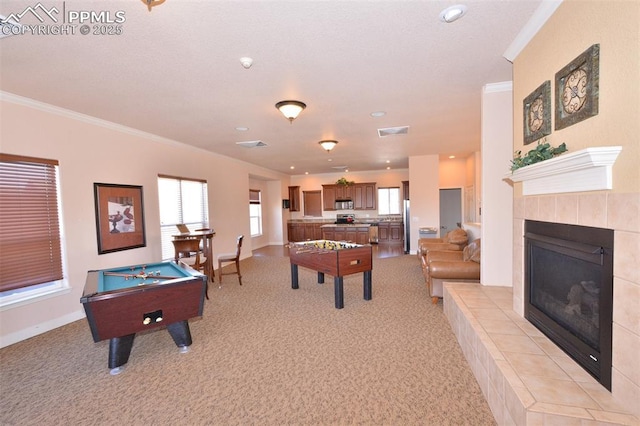 recreation room with a tiled fireplace, light carpet, billiards, and crown molding